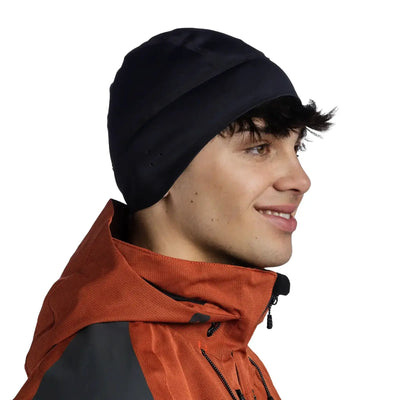 Seitenprofil eines lächelnden Mannes, der eine Buff®-Windproof-Mütze und eine orange-graue Jacke trägt.