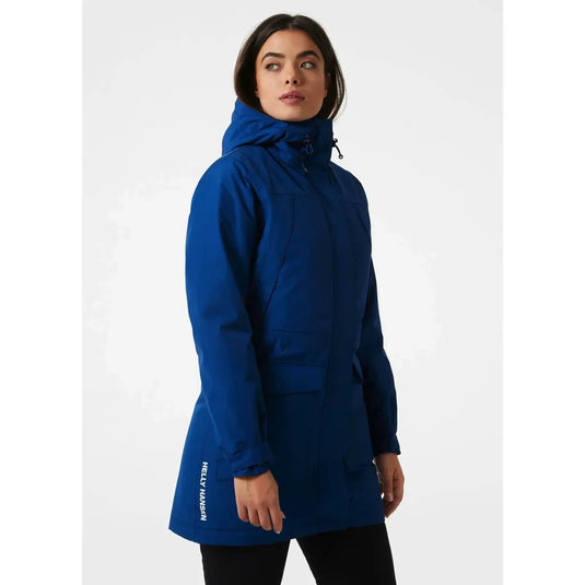 Eine Person, die einen blauen Frida-Winterparka für Damen von Helly Hansen® trägt.