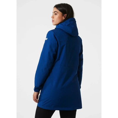 Frau trägt eine blaue Helly Hansen® Women's Frida Winter Parka-Kapuzenjacke aus der Rückansicht.