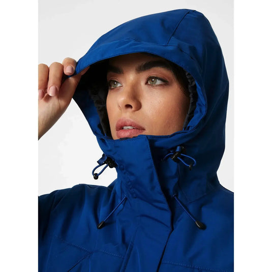 Eine Person, die die Kapuze eines blauen Helly Hansen® Women's Frida Winter Parka mit Helly Tech® Protection anpasst.