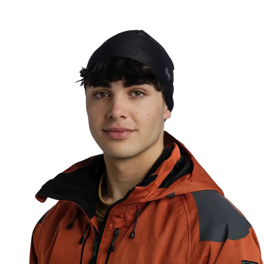 Jungmann mit einer Buff® Mütze und einer orangefarbenen Jacke.