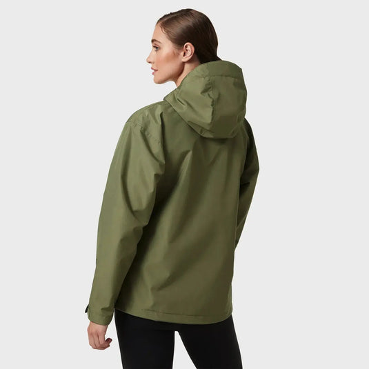 Frau trägt eine grüne wasserdichte Regenjacke „Women's Seven J Rain Jacket“ von Helly Hansen® aus der Rückansicht.