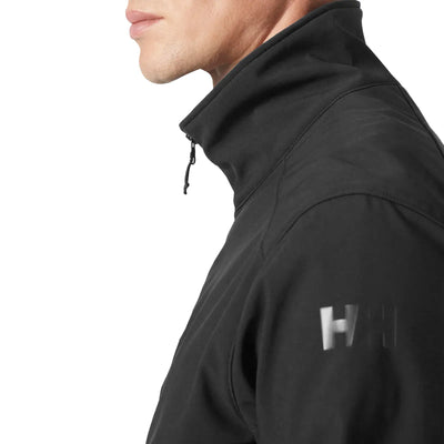 Seitenprofil eines Mannes, der eine schwarze Paramount Softshelljacke für Herren von Helly Hansen® mit einem Logo auf dem Ärmel trägt.