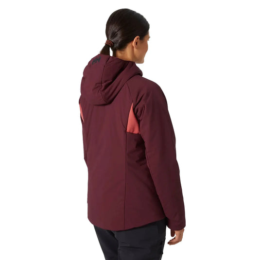 Eine Person von hinten, die eine dunkelrote Helly Hansen® Women's Odin Stretch Hood Insulator 2.0 Kapuzenjacke mit Logo auf der Kapuze trägt.