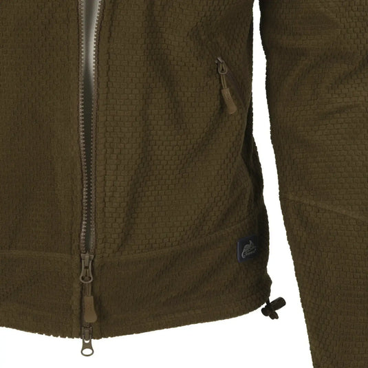 Nahaufnahme einer grün strukturierten Helikon-Tex® Alpha Tactical Jacket – Grid Fleece mit Reißverschluss und Markenlogo-Aufnäher.