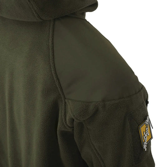 Nahaufnahme einer robusten grünen Helikon-Tex® Cumulus Hochleistungsfleecejacke mit Fleecefutter und Logo-Patch am Ärmel.