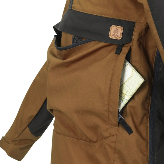 Nahaufnahme einer braunen Helikon-Tex® Woodsman Anorak Jacke mit einer Karte in der Tasche.