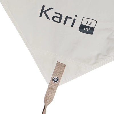 Nahaufnahme einer beigen Ecke eines Nordisk® Kari 12 Tarp aus Baumwolle mit dem Namen „Kari“ und einem Quadratmetersymbol darauf.