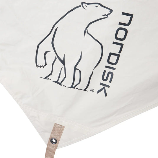 Weißer Baumwollstoff mit schwarz aufgedrucktem Logo mit einem Eisbären und dem Text „Nordisk® Kari 12 Tarp“.