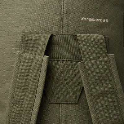 Nahaufnahme eines grünen Nordisk® Kongsberg 65 Duffle Rucksacks mit Riemen und Textdetail „Kongsberg 65“.