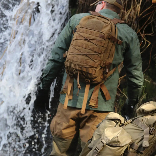 Person mit einem Helikon-Tex® RACCOON Mk2 Rucksack steht vor einem Wasserfall.