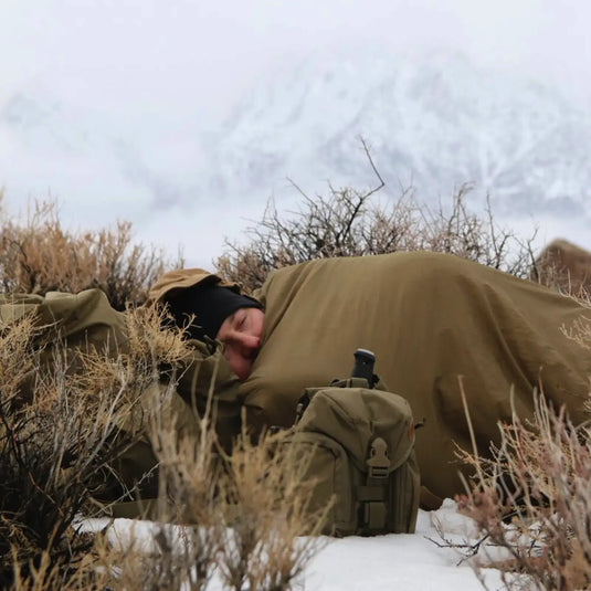 Ersetzen durch: Helikon-Tex® Swagman Roll Poncho von Helikon-Tex®

Überarbeiteter Satz: Ein Soldat, getarnt mit einem Ghillie-Anzug und einem Helikon-Tex Swagman Roll Poncho von Helikon-Tex, liegt in einer Winterlandschaft und beobachtet durch ein Fernglas.