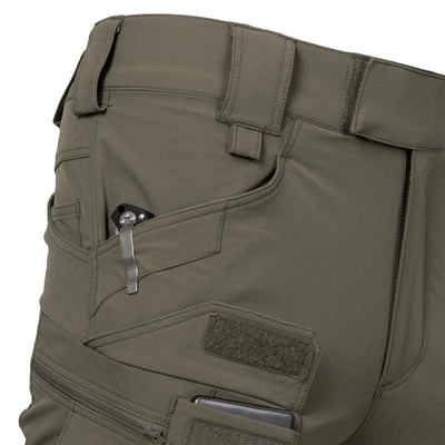 Eine Nahaufnahme einer grünen Helikon-Tex® Outdoor Tactical Pants-Tasche mit einem Taschenmesser und einem Telefon.