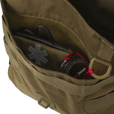 Eine teilweise geöffnete grüne Helikon-Tex® Bushcraft Haversack Bag – Cordura mit einer medizinischen Schere und einem Kompass.