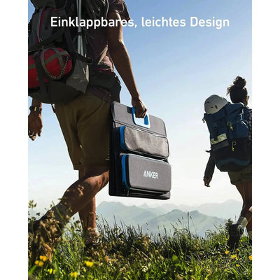 Zwei Wanderer tragen ein tragbares, zusammenklappbares ANKER 625 Solarpanel 100 W mit effizienter Technologie in den Bergen.