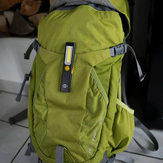 Ein grüner Rucksack mit einer Brennenstuhl® LED Akku Handlampe PL 200 A an einem seiner Riemen, flexibel einsetzbar.