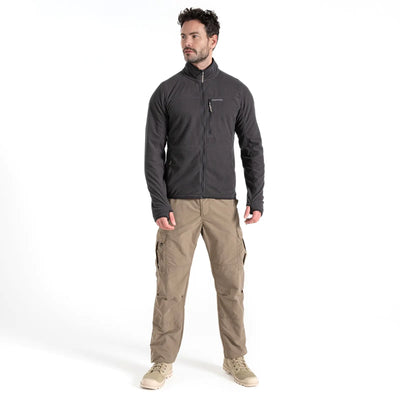 Mann steht in einem Studio und trägt eine Craghoppers NosiLife Spry Jacke für Herren und eine NosiLife Spry Khaki-Cargohose, perfekt für ein Outdoor-Abenteuer.