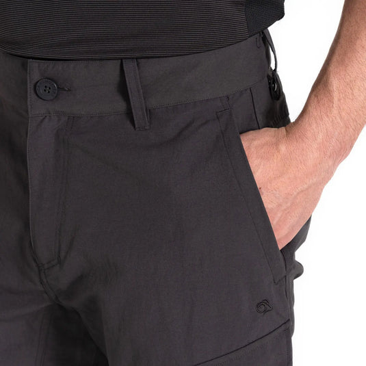 Nahaufnahme einer Person in schwarzer Hose mit Craghoppers NosiLife Adventure Hose III für Herren und einer Hand in der Tasche.