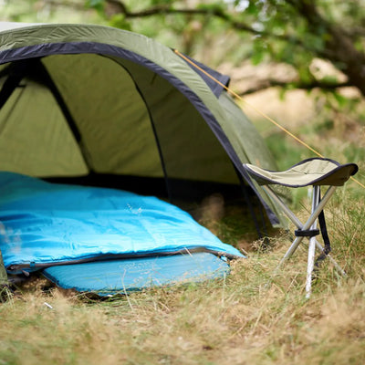 Ein Campingzelt mit einer Grand Canyon® Hattan 3.8-Matratze und einem Klappstuhl, aufgebaut in einer natürlichen Umgebung.