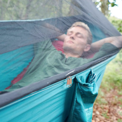 Mann ruht sich in einer Grand Canyon® Bass Mosquito Hammock mit Insektenschutzgitter im Freien aus.