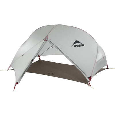 Ein freistehendes, ultraleichtes Backpacking-Zelt MSR® Hubba Hubba™ NX V7 mit einem grauen Regenflieger und roten Akzenten.