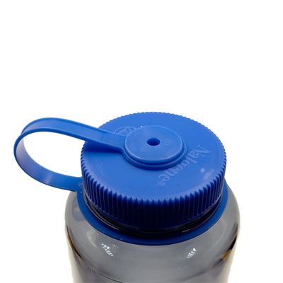 Blaue Nalgene® Trinkflasche „Wide Mouth“ 1,0 L Plastikflaschenverschluss mit Klappdeckel auf einer transparenten Flasche, isoliert auf weißem Hintergrund.