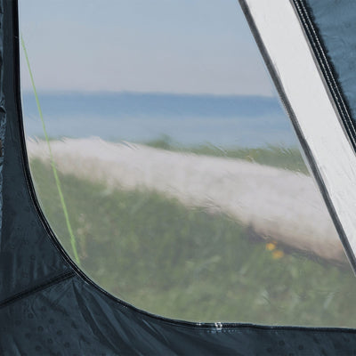 Blick auf einen Strand und das Meer durch das Fenster eines Outwell® 5-Personen Zelt - Cloud 5 Zeltes.