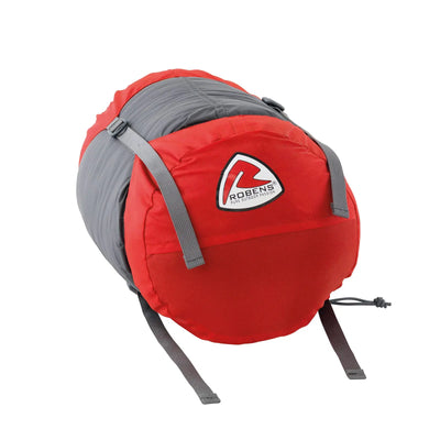 Rot-grauer Robens® Schlafsack Gully 300 +4°C aufgerollt und mit Gurten gesichert vor weißem Hintergrund.