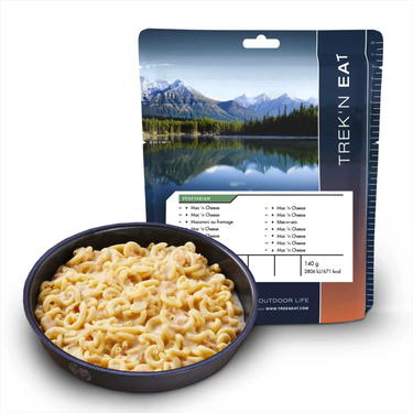 Eine vegetarische Mac'n Cheese-Mahlzeit von Trek'n Eat im Freien neben einer Schüssel mit dem zubereiteten Produkt.